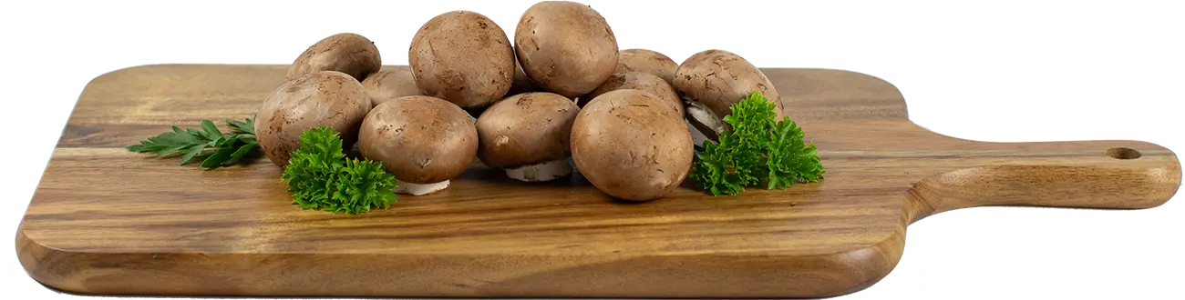 Brown (crimini) mushrooms with parsley on a wood cutting board