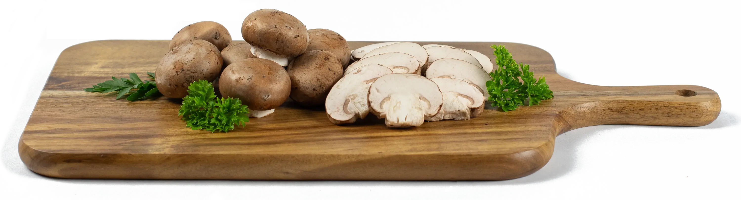 Whole and sliced brown (crimini) mushrooms on a wood cutting board with parsley
