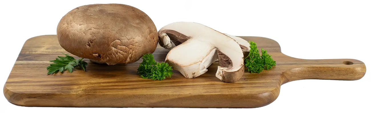 Whole and sliced portabella mushrooms on a wood cutting board