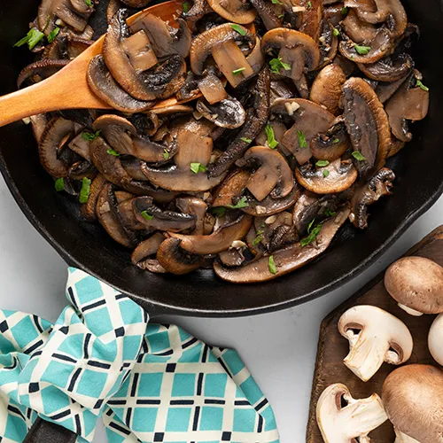 Sautéed mushrooms with garlic and parsley in a turquoise bowl