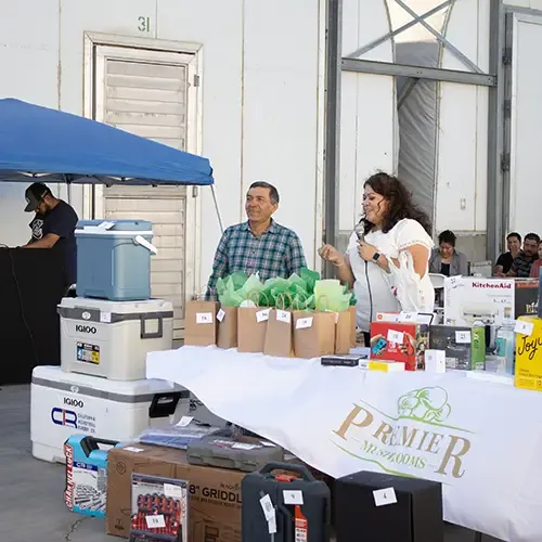 Staff by a table with goodies and a Premier logo