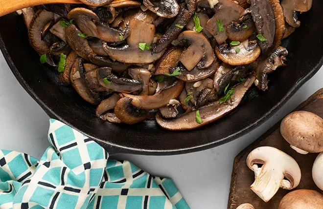 Sautéed mushrooms with garlic and parsley in a turquoise bowl