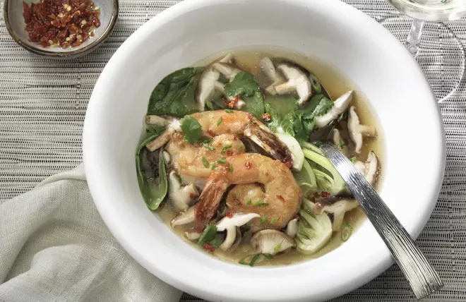 Shiitake broth with ginger prawns in a white bowl