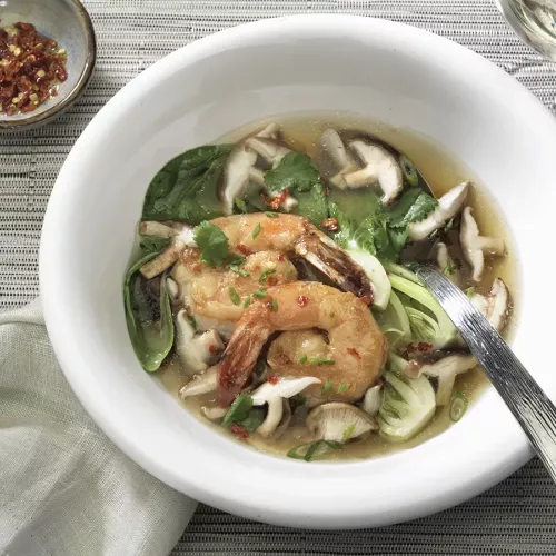 Shiitake broth with ginger prawns in a white bowl