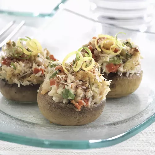 3 cajan seafood stuffed mushrooms on a white plate