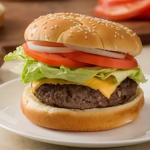 A blended burger on a sesame bun with tomatoes, red onion, lettuce and cheese.